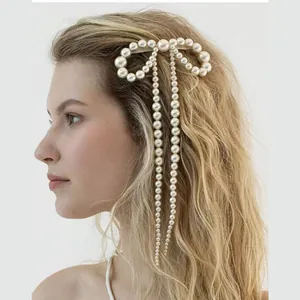 Détail de la pince à cheveux nœud en perles avec de longues pampilles élégantes pour mariée
