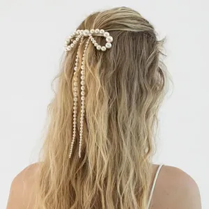 Détail de la pince à cheveux nœud en perles avec longues franges sur le modèle