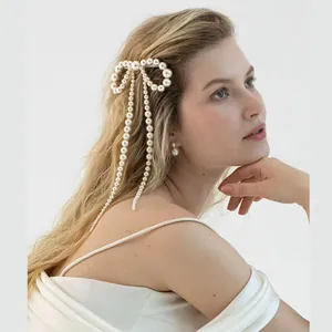 Barrette élégante en perles avec nœud et pampilles pendantes sur la coiffure d'un modèle