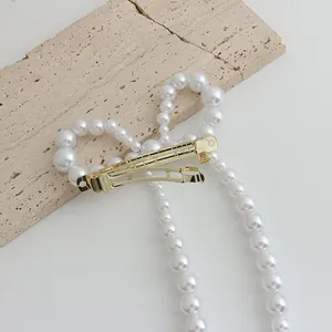 Gros plan d'une barrette à perles élégante avec base dorée sur surface en pierre