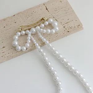 Vue détaillée de la pince à cheveux avec nœud en perles, pompons et alliage doré élégant