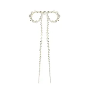 Détail d'une pince à cheveux en perles avec nœud et longs pompons élégants blancs