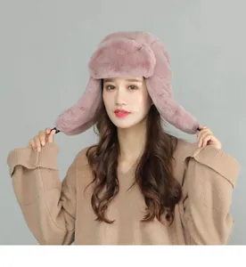 Close-up of pink faux rabbit fur trapper hat with thick plush texture and ear flaps
