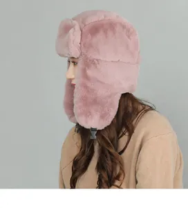 Pink plush trapper hat for winter with side earflaps and buckle strap on model