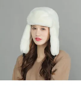 Detail of white plush trapper hat showing soft faux fur texture and black chin strap buckles