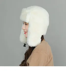 Detail of white plush trapper hat showing thick faux fur texture and adjustable chin strap