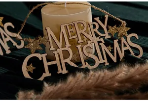 Primo piano di una targa in legno Merry Christmas con stelle glitterate dorate