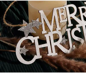 Dettaglio macro di un cartello in legno Merry Christmas con stelle glitterate argentate.