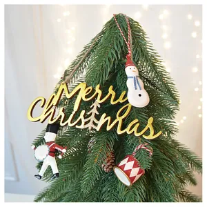 Vista dettagliata di una targa in legno Merry Christmas e figurine festive su un albero di Natale