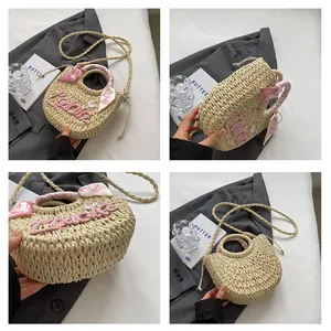 Detail of round straw bag with Lucky embroidery and floral scarf wrapped handle