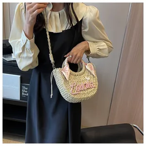Straw basket bag featuring pink Ladala embroidery and floral scarf wrapped handle detail