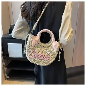 Detail of beige straw crossbody bag with pink Lala embroidery and floral scarf handle