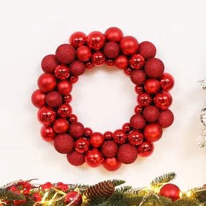 Detail of a red Christmas wreath featuring glossy, matte, and glitter ball ornaments