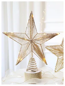 Detail of champagne gold glitter star tree topper with warm LED lights and spiral base