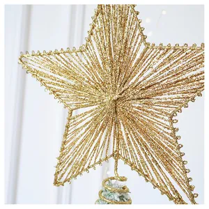 Close-up of golden glitter Christmas tree star topper with wire frame and spiral base