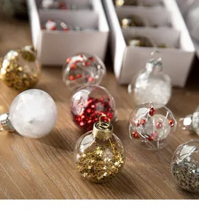 Detail of clear Christmas baubles with various festive fillings on wooden table