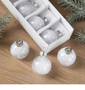 Close-up of clear Christmas baubles with white feather filling displayed in a white gift box
