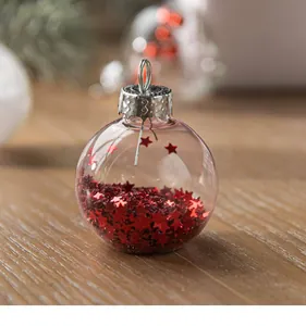 Close-up detail of a transparent glass Christmas ball ornament filled with red star sequins