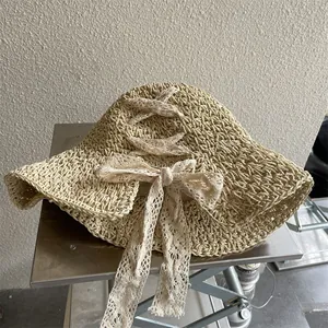 Close-up of the delicate lace bow and intricate crochet weave on a straw sun hat