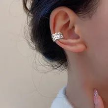 Detail view of silver hollow lace ear cuff on ear without piercing for women