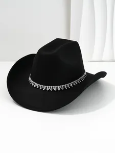 Vista dettagliata delle frange di strass argentati e catene su un cappello da cowboy nero