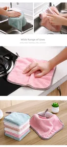 Detailed view of pink coral fleece dishcloth cleaning a ceramic plate with thick texture