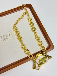 Close-up of golden necklace featuring a leopard head pendant with colorful enamel and diamonds