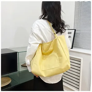 Side view of large yellow canvas tote bag showing spacious design on female model
