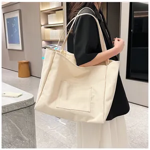 Lifestyle shot of cream canvas tote bag with outer pocket showing large capacity and strap