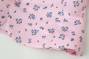Detailaufnahme des rosa Blumenoberteils mit Stoffknöpfen und feiner Stickerei für Damen