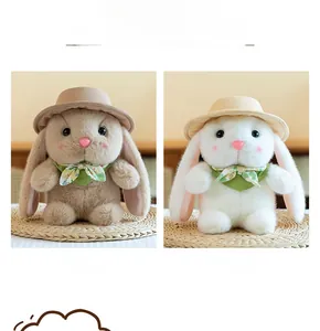 Close-up of cute plush bunny toys with hats and floral scarves on straw mats