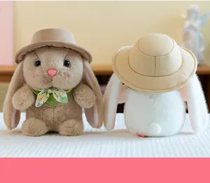 Detail of plush bunny pair with tiny sun hats and floral scarves on a white surface