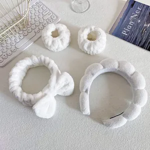 Close-up of white plush spa headband set with matching wristbands and cloud hairband