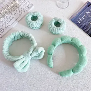 Detail of mint green plush headband set with bow and wristbands for face washing