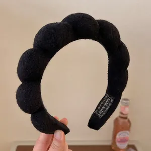 Padded black braided sponge headband with soft knit texture and handmade label