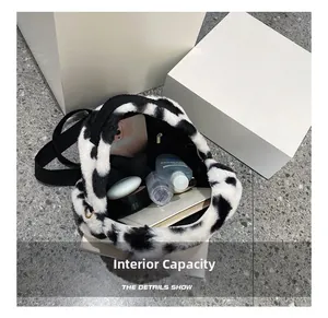 Internal capacity of cow print plush bag showing phone and cosmetics storage