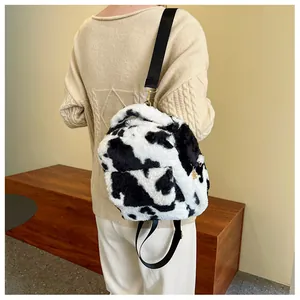 Detail view of cow print plush backpack with soft faux fur and adjustable straps