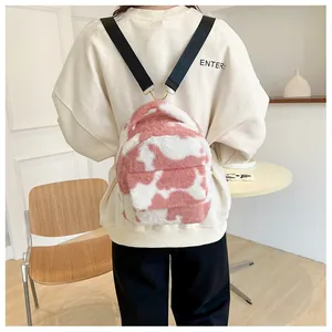 Detail of plush pink cow print mini backpack with adjustable black shoulder straps