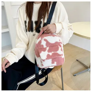 Detail of pink cow print plush backpack showing fuzzy texture and soft shoulder straps