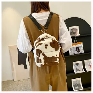 Detail of soft faux fur cow print backpack with adjustable straps and metal hardware