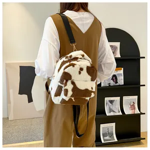Detail of cow print plush backpack with black nylon straps and golden metal hardware