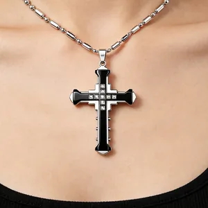 Detail of silver cross pendant with black enamel inlay and centered diamond accents