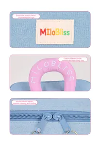 Detail of soft padded pink handle, dual zippers, and brand label on a blue travel bag