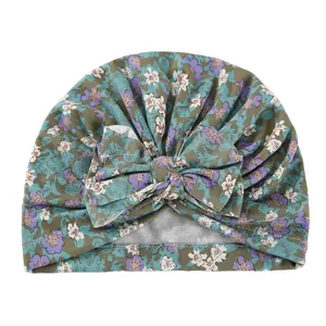 Close-up of olive green floral baby turban hat with a large decorative bow