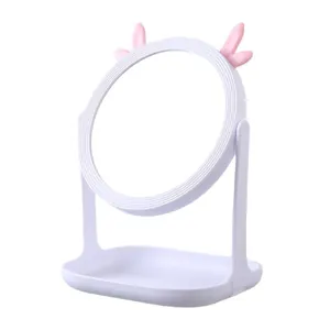 Desktop makeup mirror with pink antlers and rotating round glass on storage base