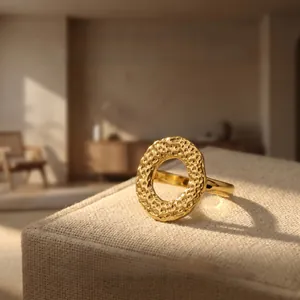 Detail of 18K gold-plated irregular ring showing handcrafted hammered texture on fabric