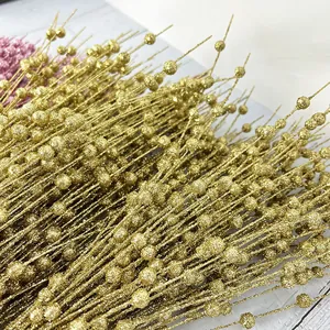 Detail shot of sparkling gold Christmas berry stems with glitter coating and beaded texture