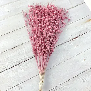 Close-up of pink glitter Christmas berry stems with sparkling texture on white wood background