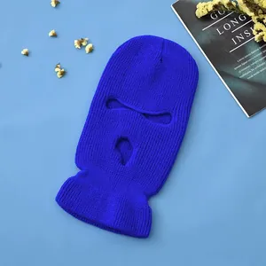 Detail of a bright blue 3-hole knitted balaclava mask showing thick wool texture and eye holes