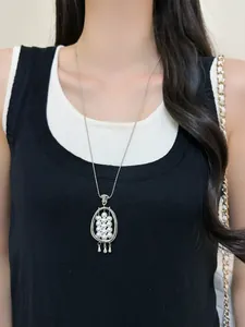 Close-up of elegant silver long necklace featuring a pearl flower pendant on model